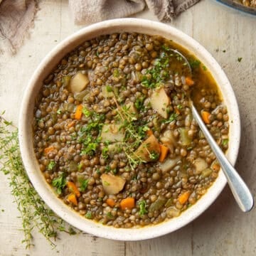 Bowl of French Lentil Soup with fresh thyme on top.