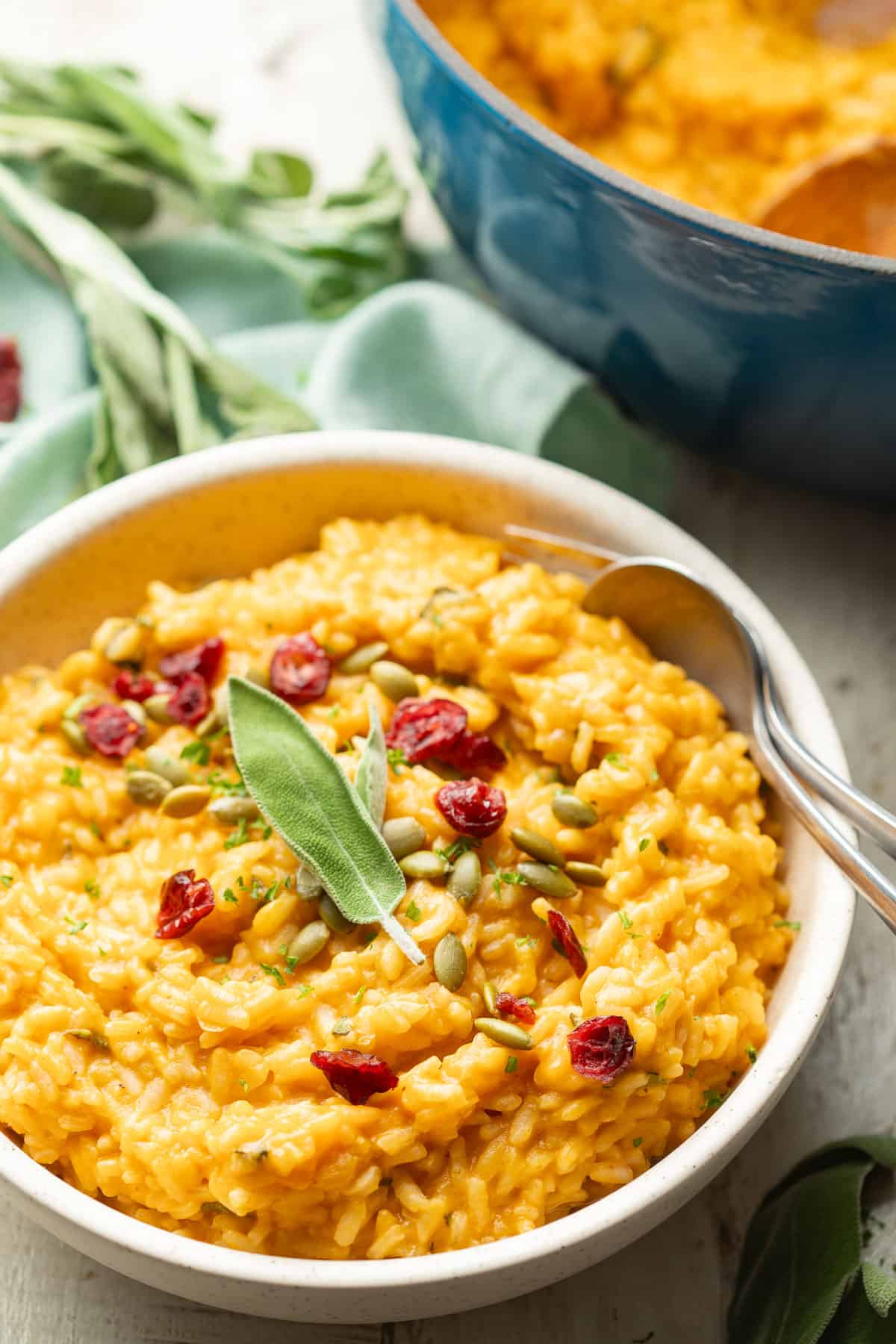Bowl of Pumpkin Risotto with a blue pot in the background.