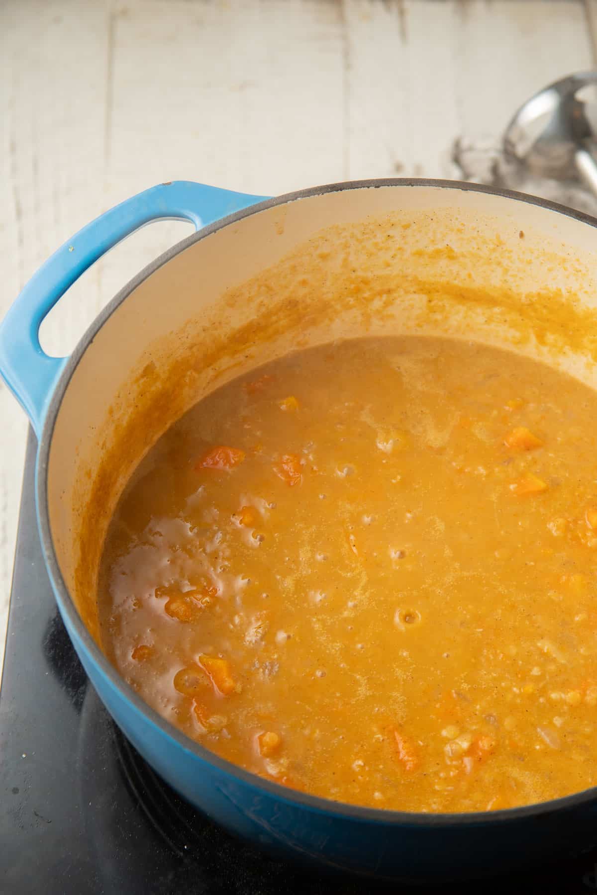 Red Lentil Butternut Squash Soup simmering in a pot.