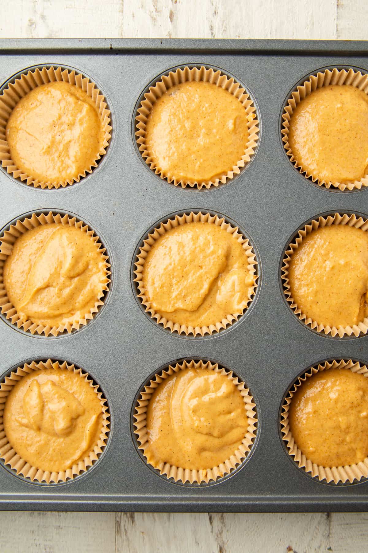 Vegan Pumpkin Cupcake batter in a muffin tin.