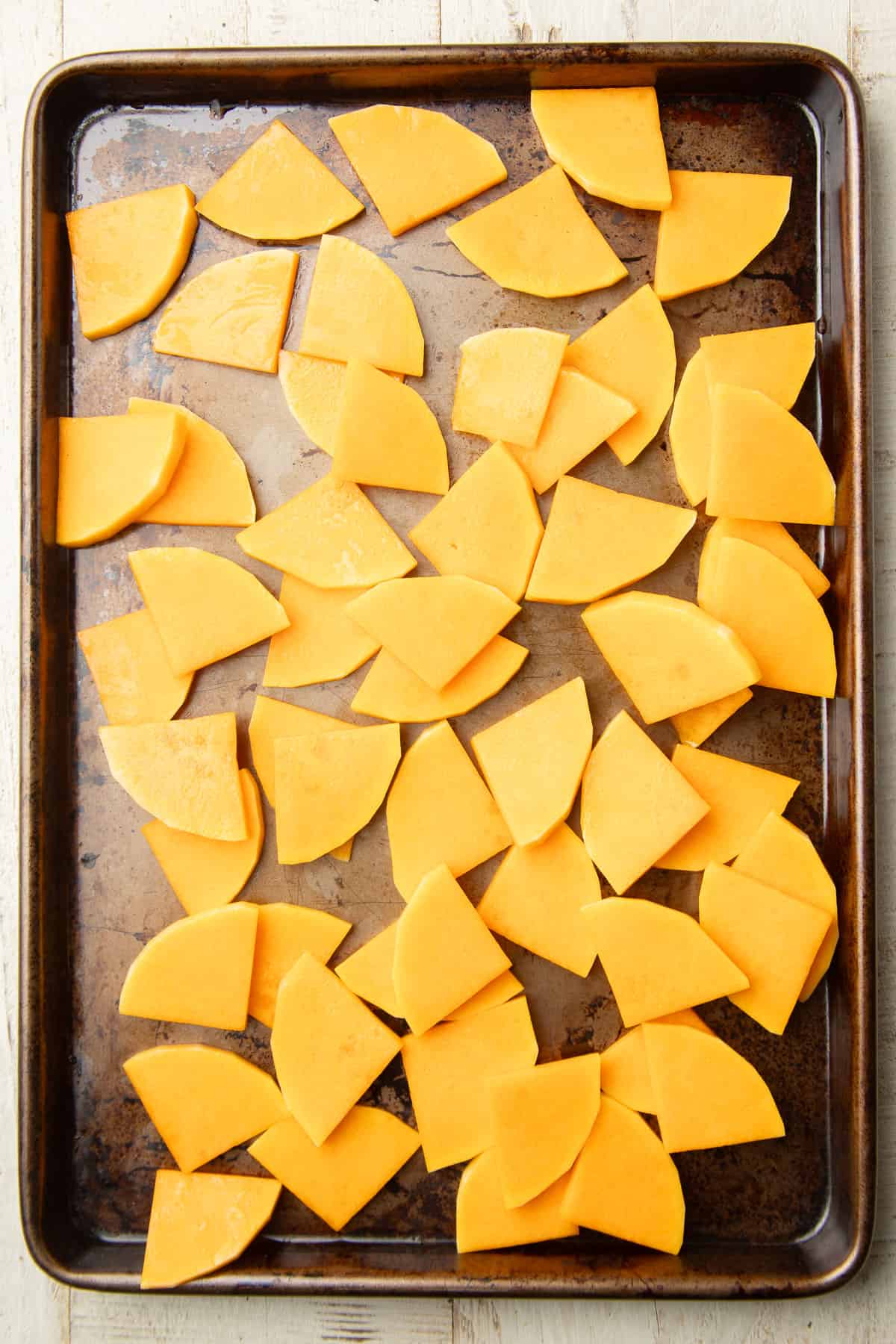 Butternut squash slices on a baking sheet.