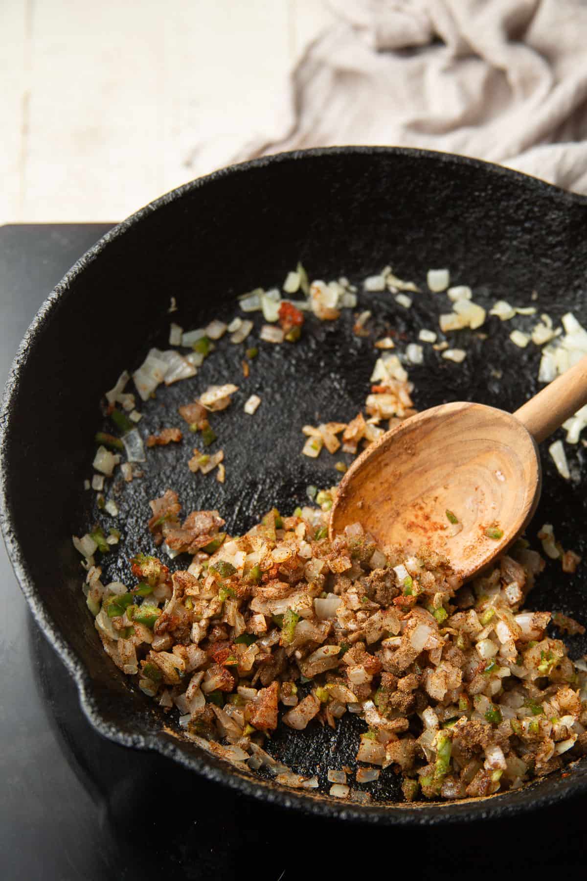 Onions, garlic, and spices cooking in a skillet.