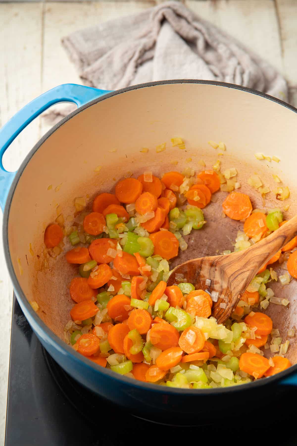 Carrots, onions, and celery cooking in a pot.