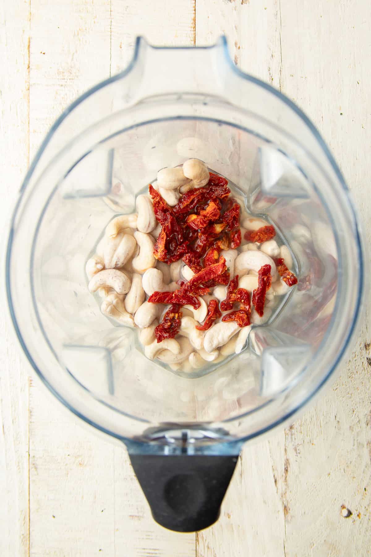 Cashews and sundried tomatoes in liquid in a blender.