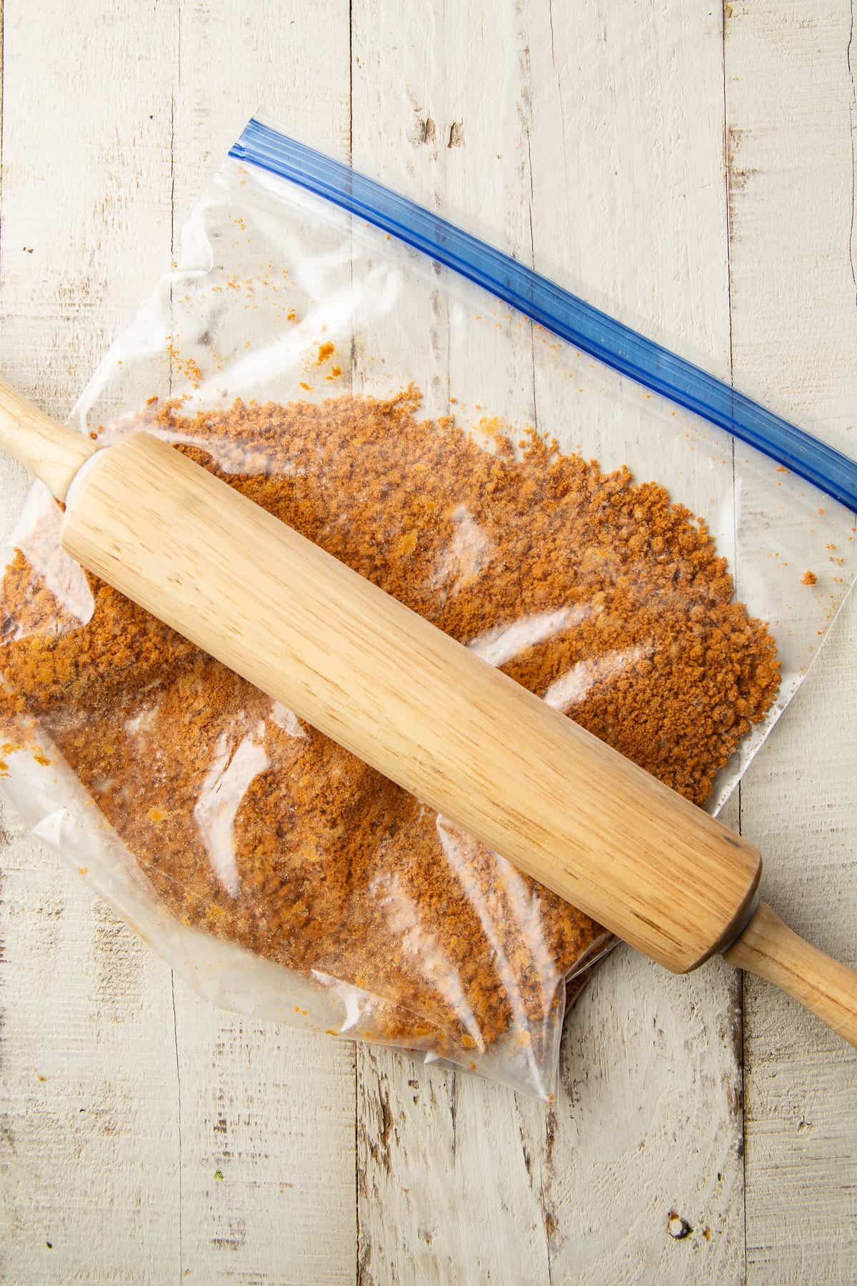 Bag of cookie crumbs with a rolling pin on top.