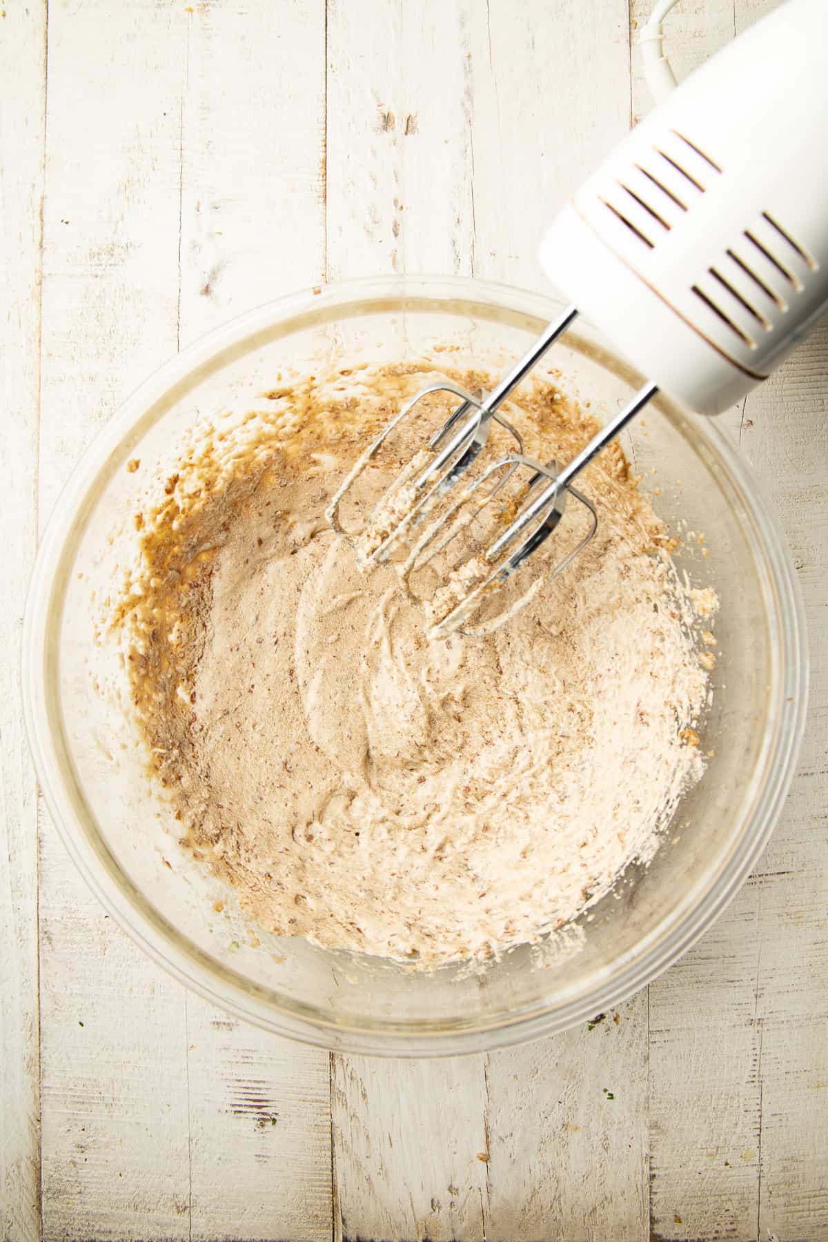Blend of vegan butter, brown sugar, and flax egg in a mixing bowl with electric mixer.