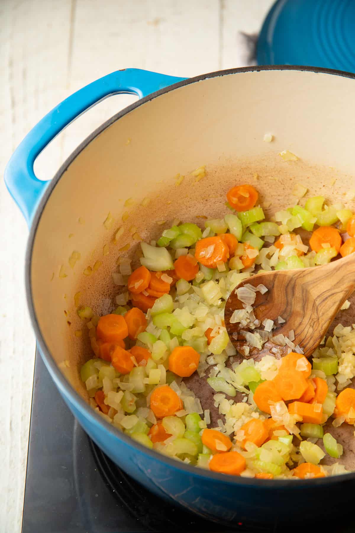 Carrots, celery, and diced onion cooking in a pot.