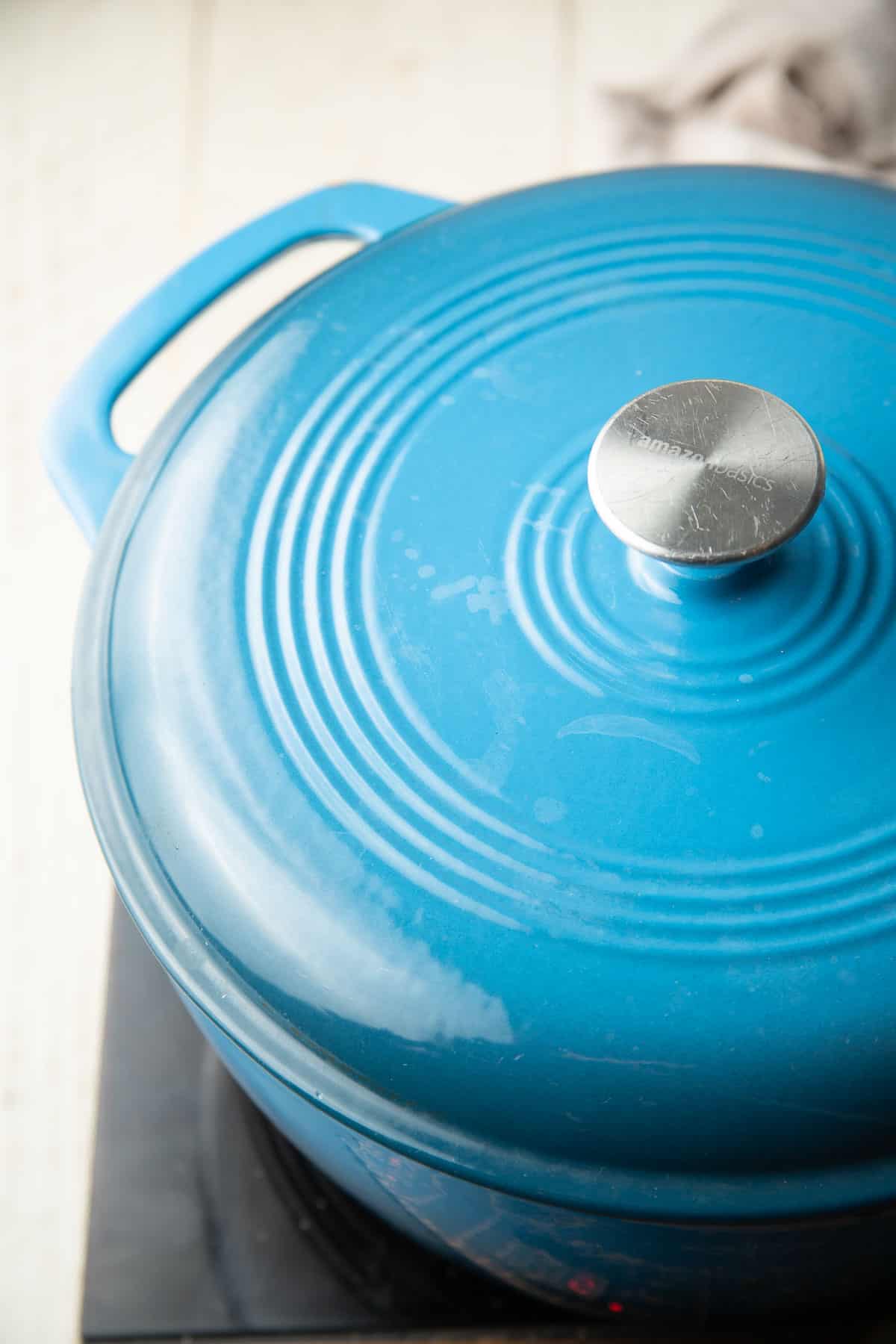 Blue Dutch oven with a lid on top.