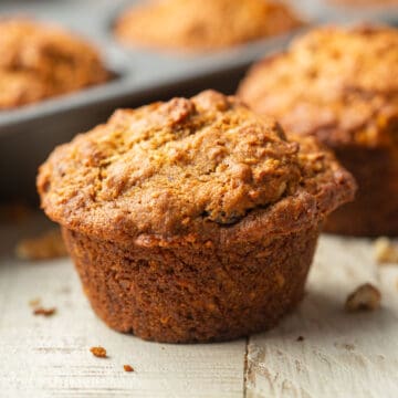 Vegan Morning Glory Muffin in front of a muffin tin.