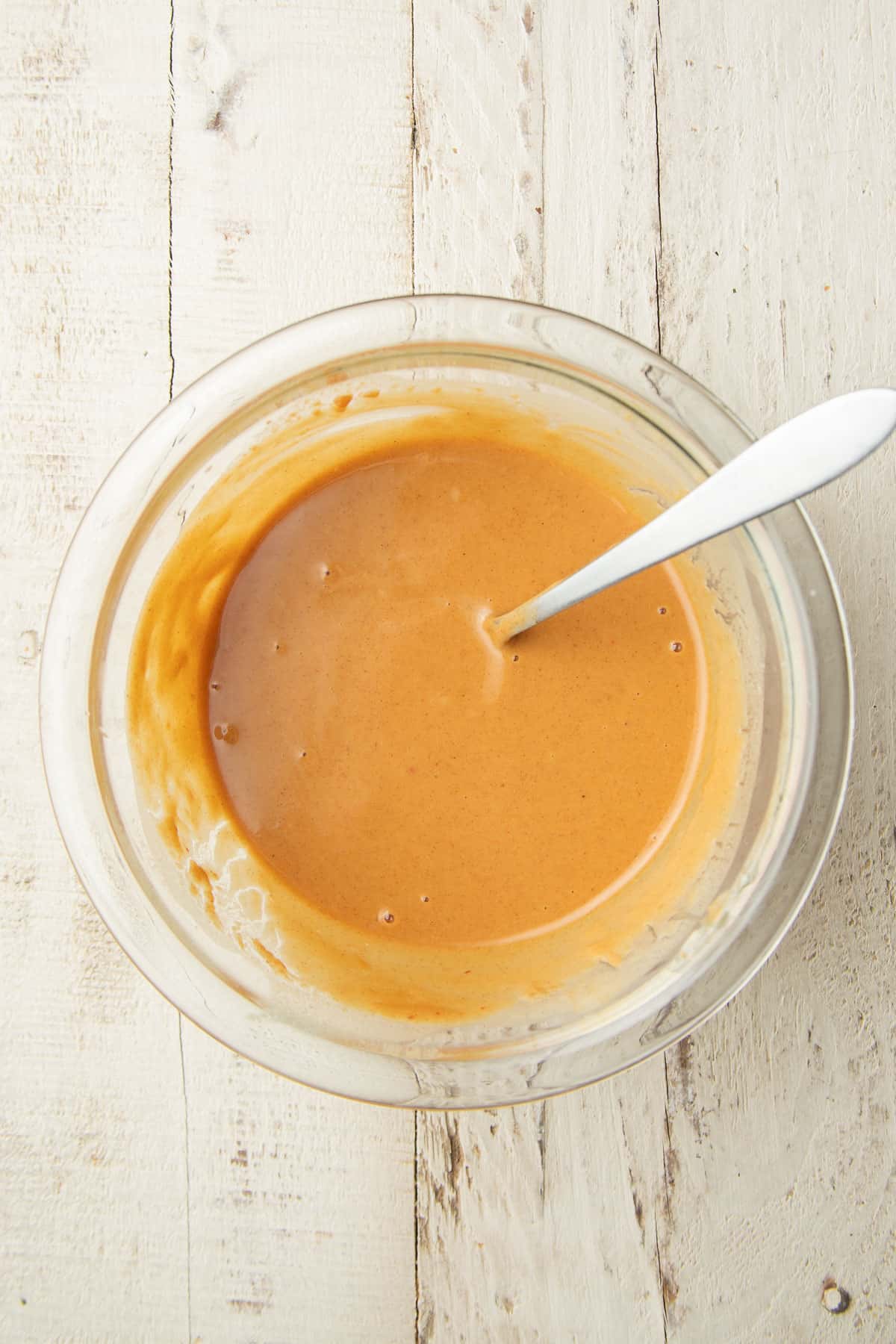 Peanut sauce in a glass bowl with spoon.