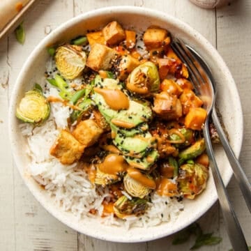 Peanut tofu bowl with a fork and spoon.