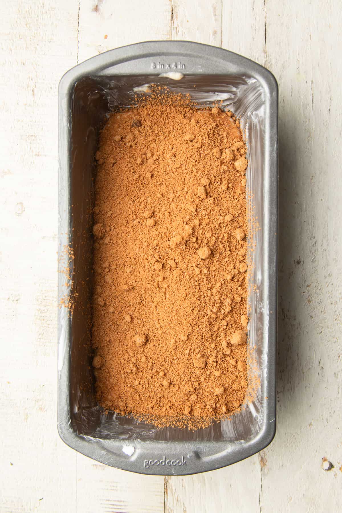 Quick bread batter in a loaf pan topped with a layer of cinnamon brown sugar.