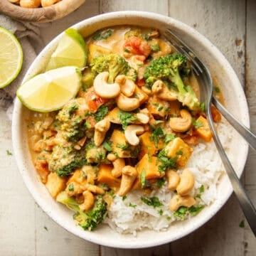 Bowl of Cashew Curry over rice with a fork and spoon.