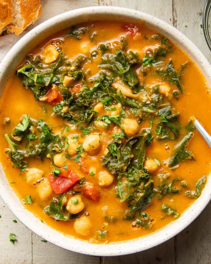 Bowl of Curried Chickpea Kale Soup with spoon.