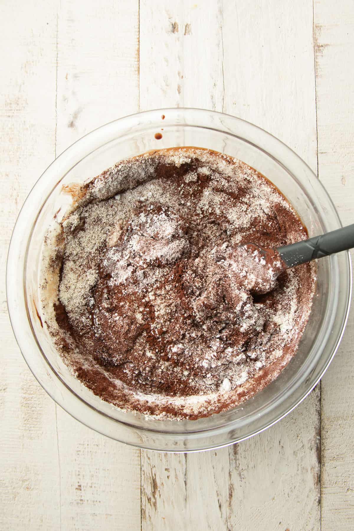 Melted chocolate in a mixing bowl with almond flour added.