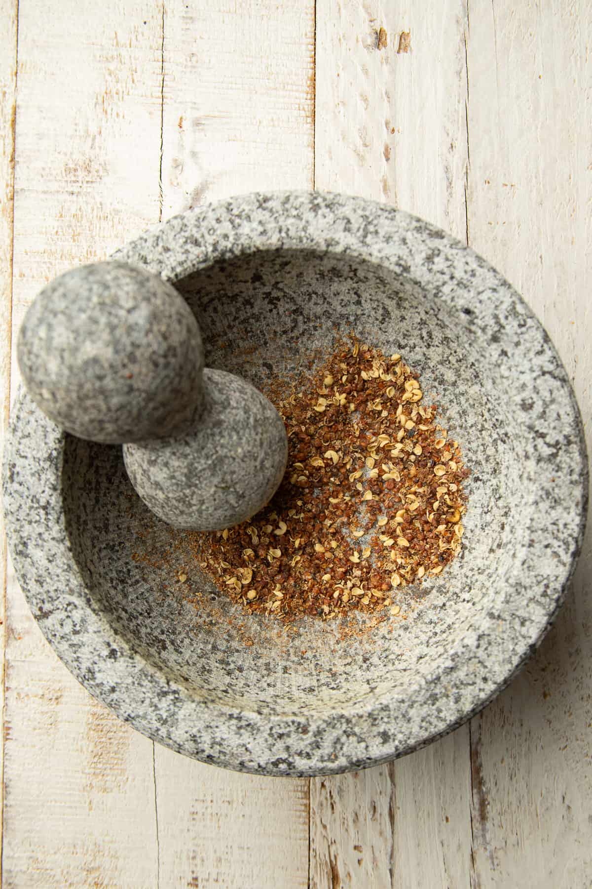 Crushed szechuan peppercorns in a mortar and pestle.