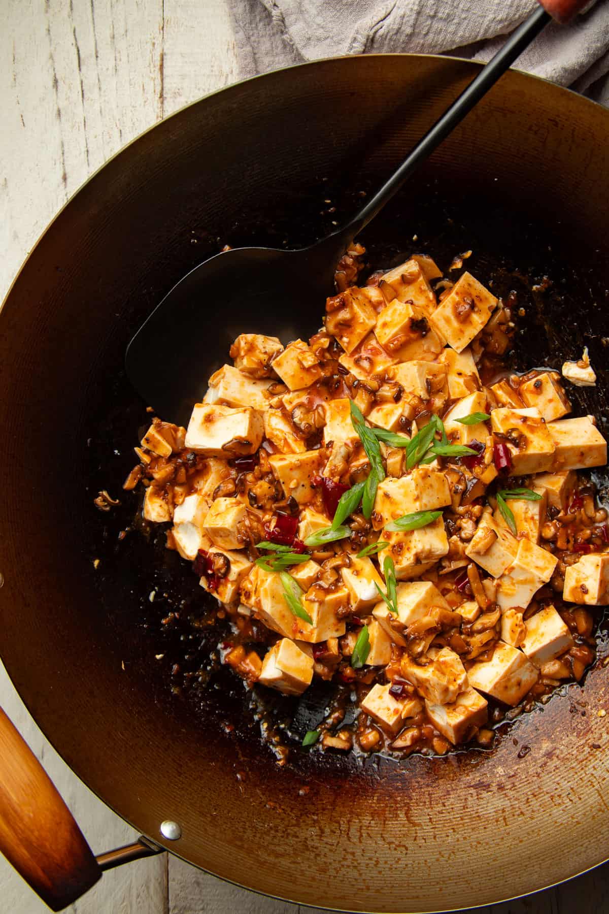 Vegan Mapo Tofu in a wok with spatula.