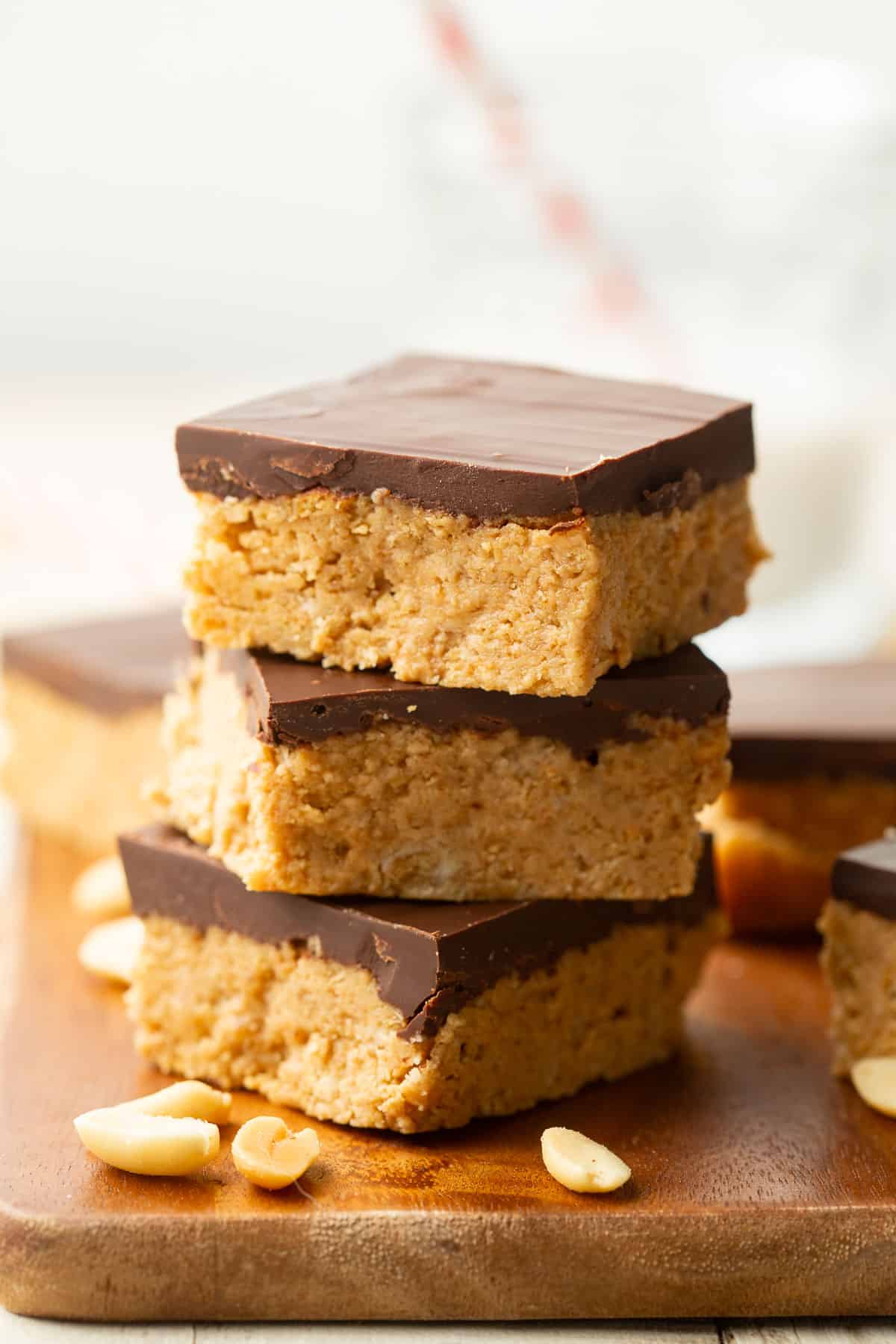 Stack of three Vegan Peanut Butter Bars on a wooden surface.