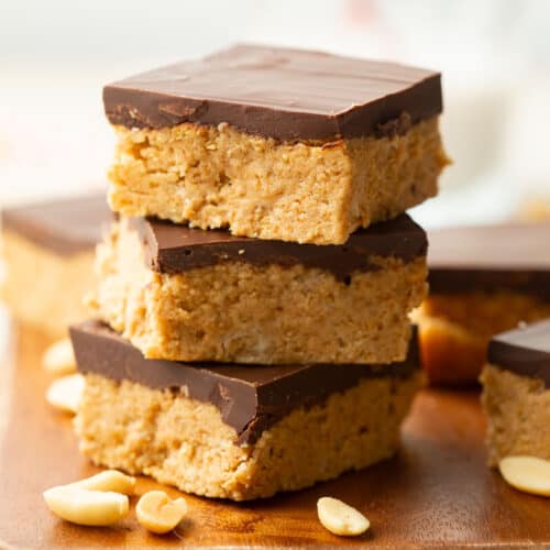 Stack of three Vegan Peanut Butter Bars on a wood surface.