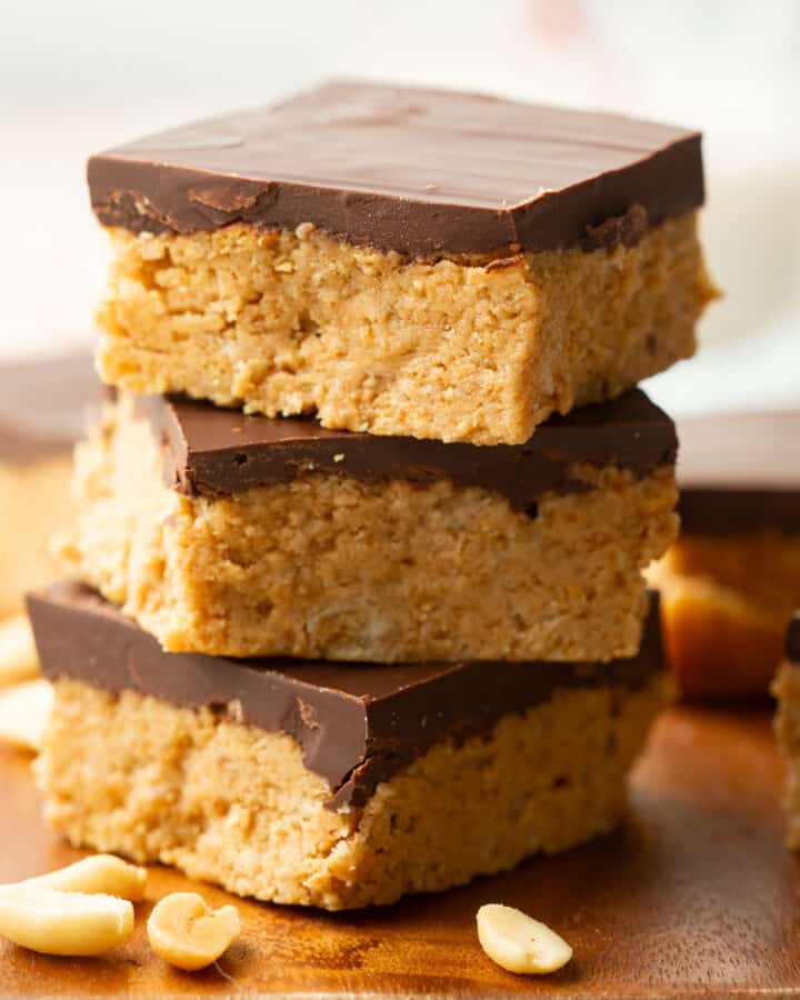 Stack of three Vegan Peanut Butter Bars on a wood surface.