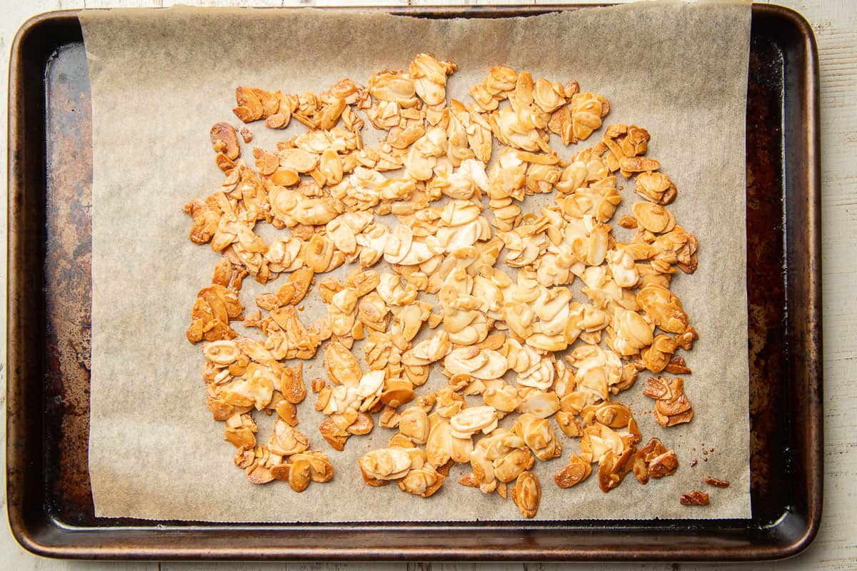 Maple ginger roasted almonds on a parchment paper lined baking sheet.