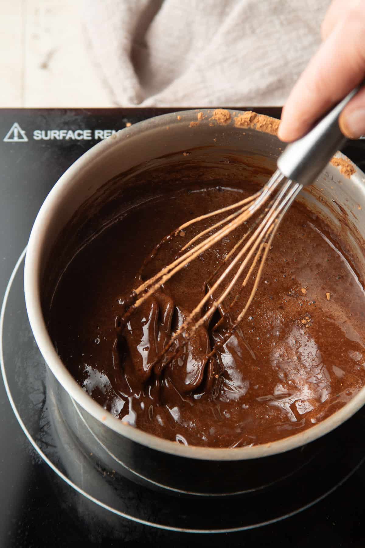 Hand whisking guinness, melted vegan butter, cocoa and sugar together in a saucepan.