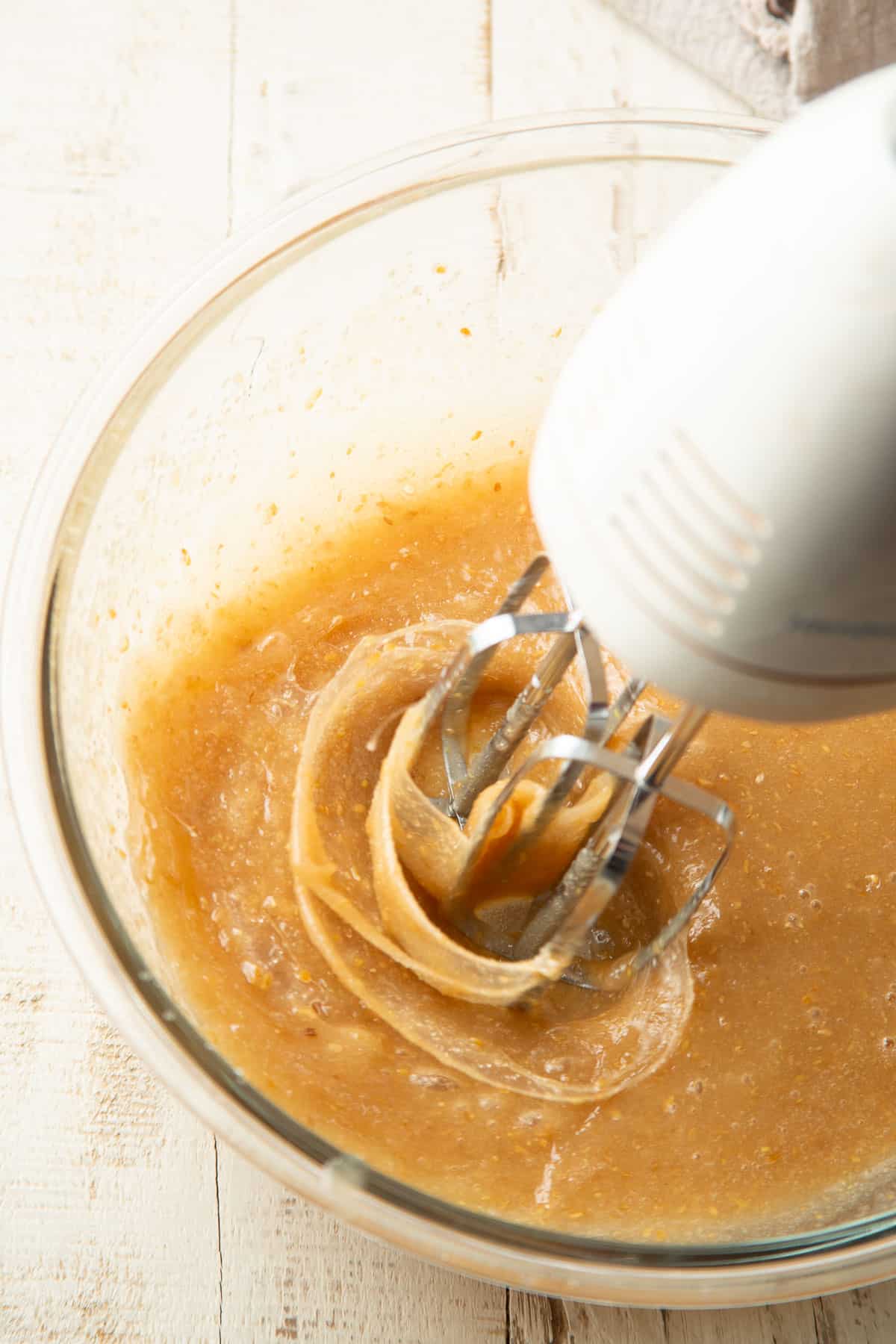 Flax egg and sugar begin whipped in a bowl with an electric mixer.