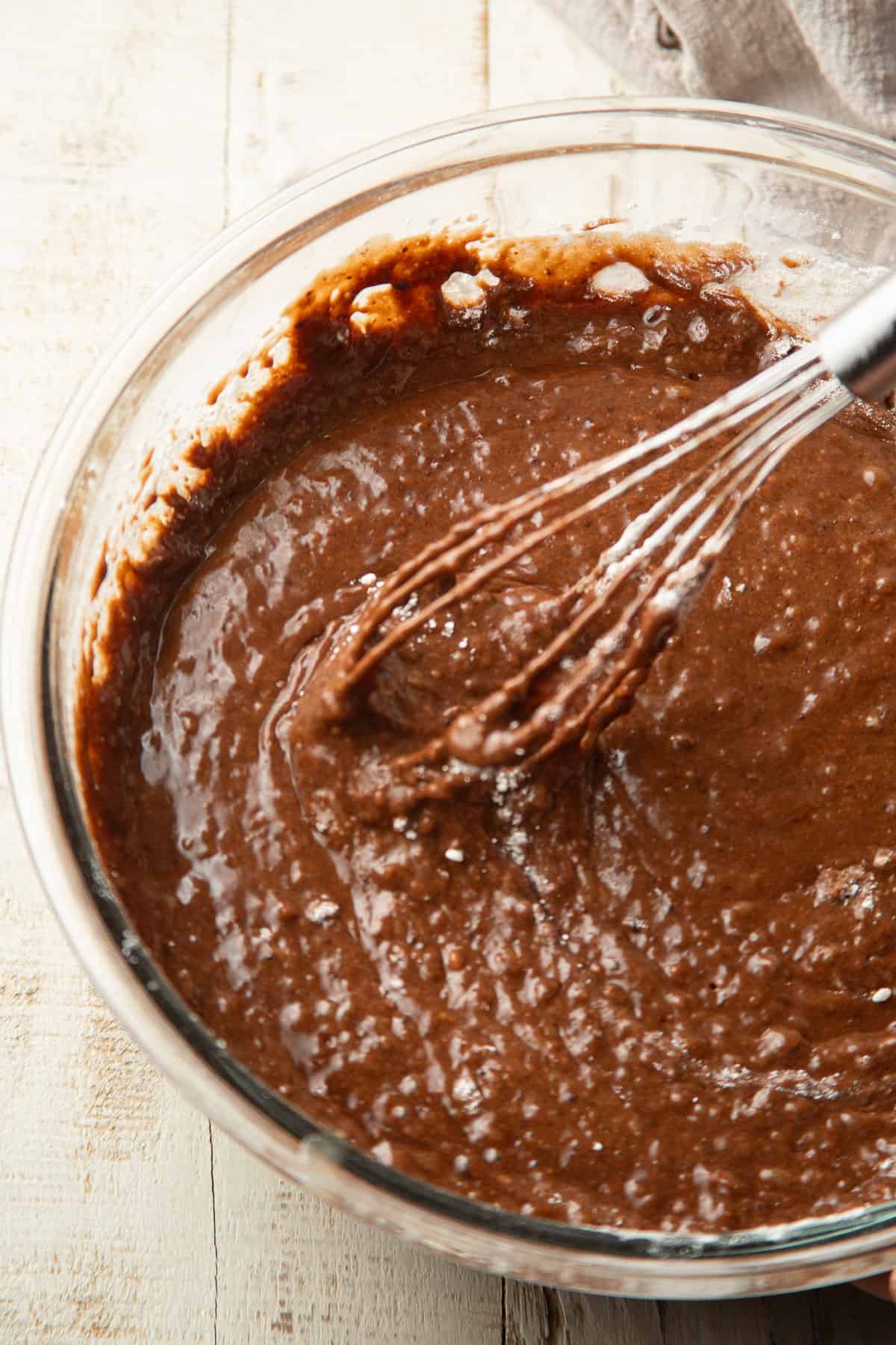 Chocolate cake batter in a bowl with whisk.