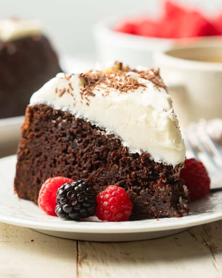 Slice of Vegan Guinness Cake on a dish with fresh berries.