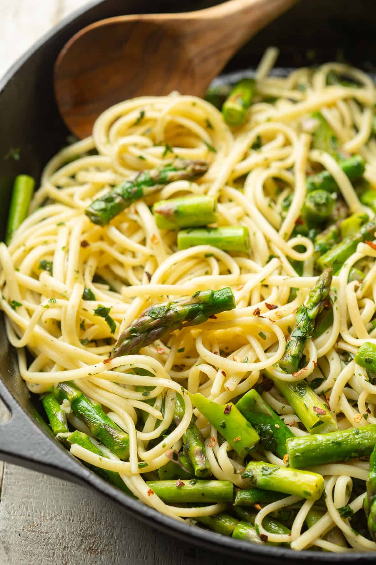 Pasta Gremolata with Asparagus in a skillet with a wooden spoon.