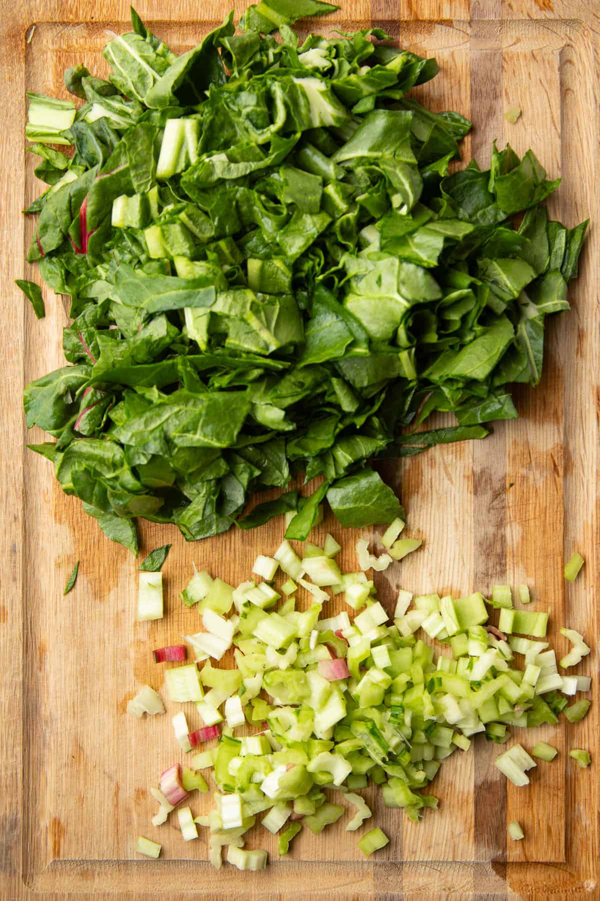 Chopped Swiss chard leaves and stems on a cutting board.