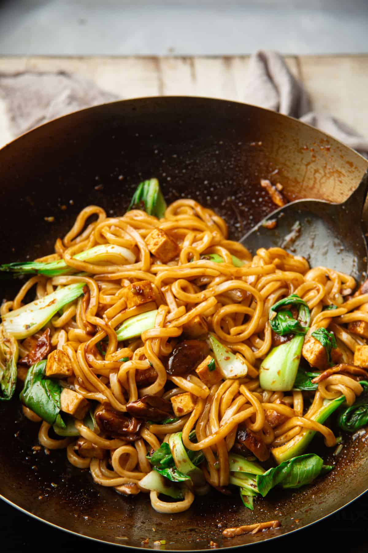 Udon Noodle Stir-Fry cooking in a wok.