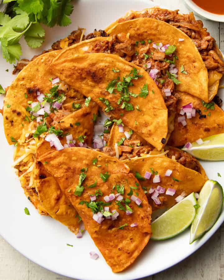 Vegan Birria Tacos on a plate with lime wedges.