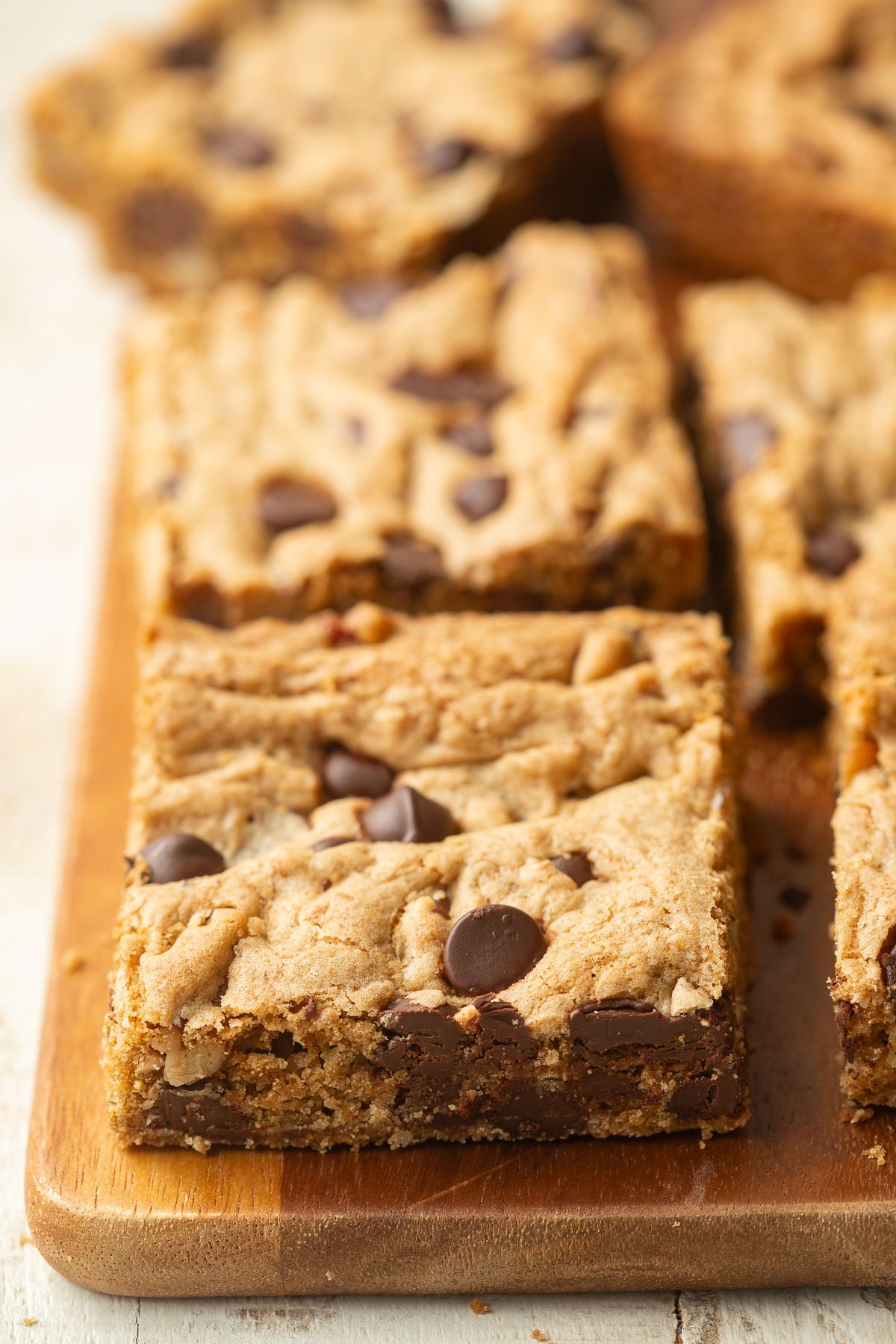 Vegan Chocolate Chip Cookie Bars on a wooden board.