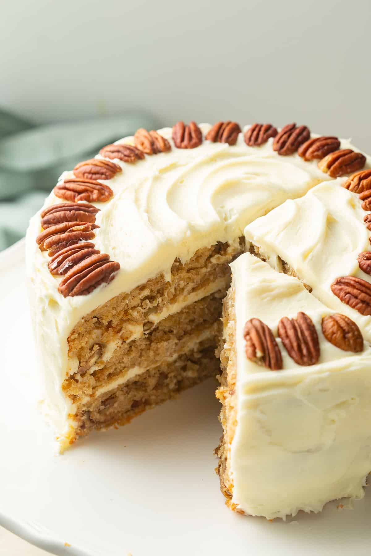 Vegan Hummingbird Cake with a slice cut out on a cake dish.