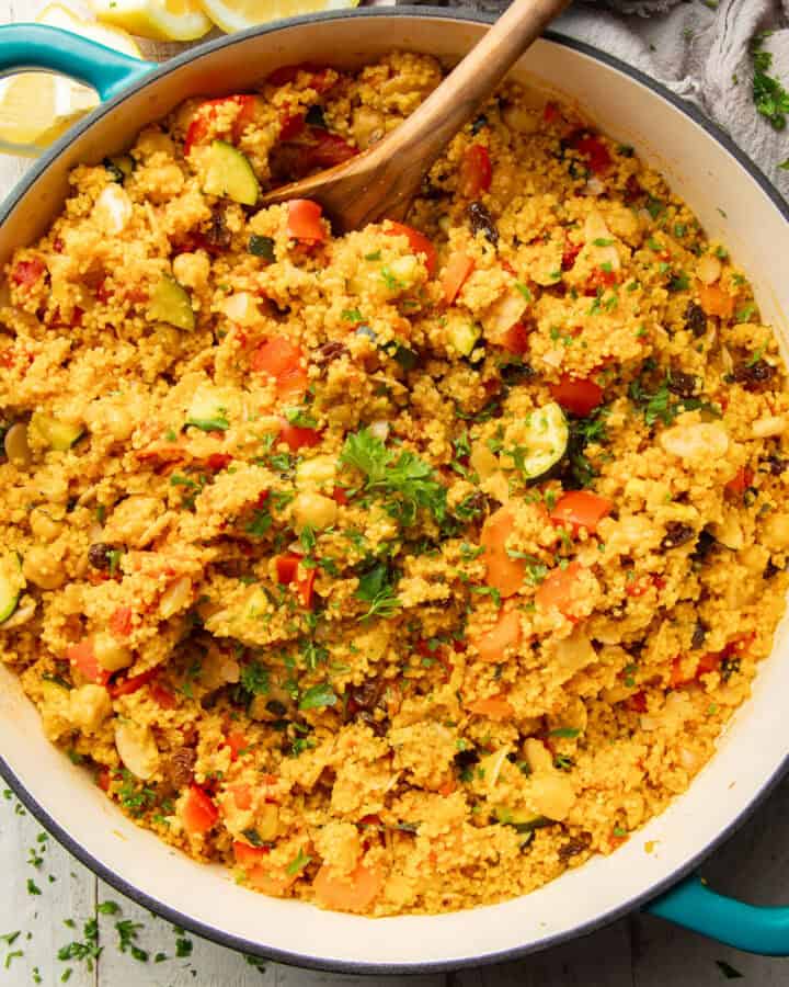 Pot of Moroccan Couscous with a wooden spoon.