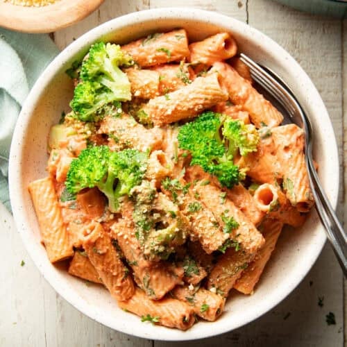Bowl of Pasta with Vegan Rosé Sauce and broccoli with a fork and spoon.