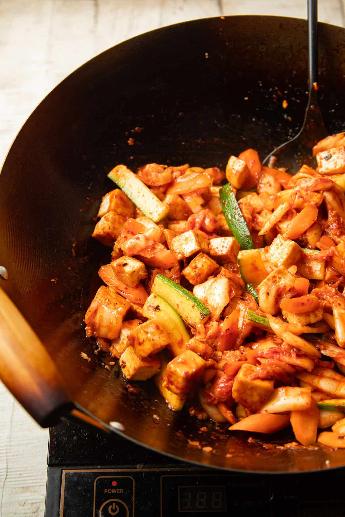 Kimchi Stir-Fry with tofu cooking in a wok.