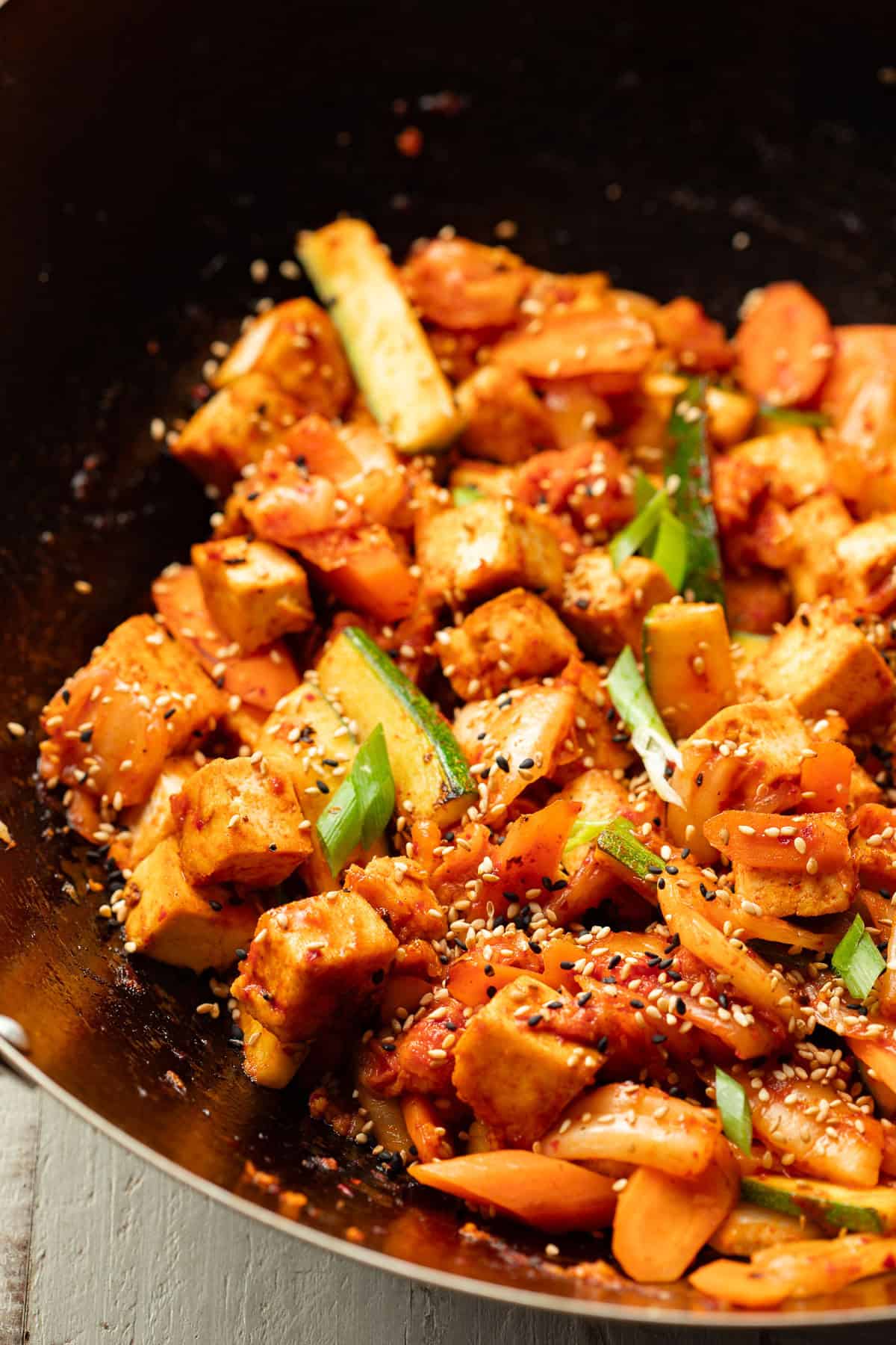 Kimchi Stir-Fry topped with sesame seeds in a wok.