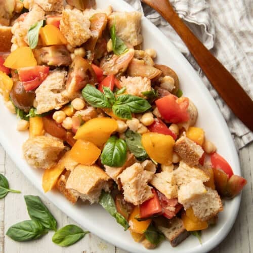 Plate of Vegan Panzanella topped with fresh basil leaves.