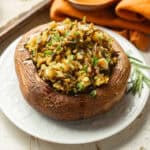 Rice Stuffed Portobello Mushroom on a plate with a rosemary sprig.