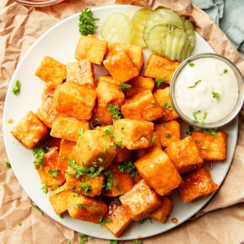 Plate of Nashville Hot Tofu bites with pickle slices and ranch.
