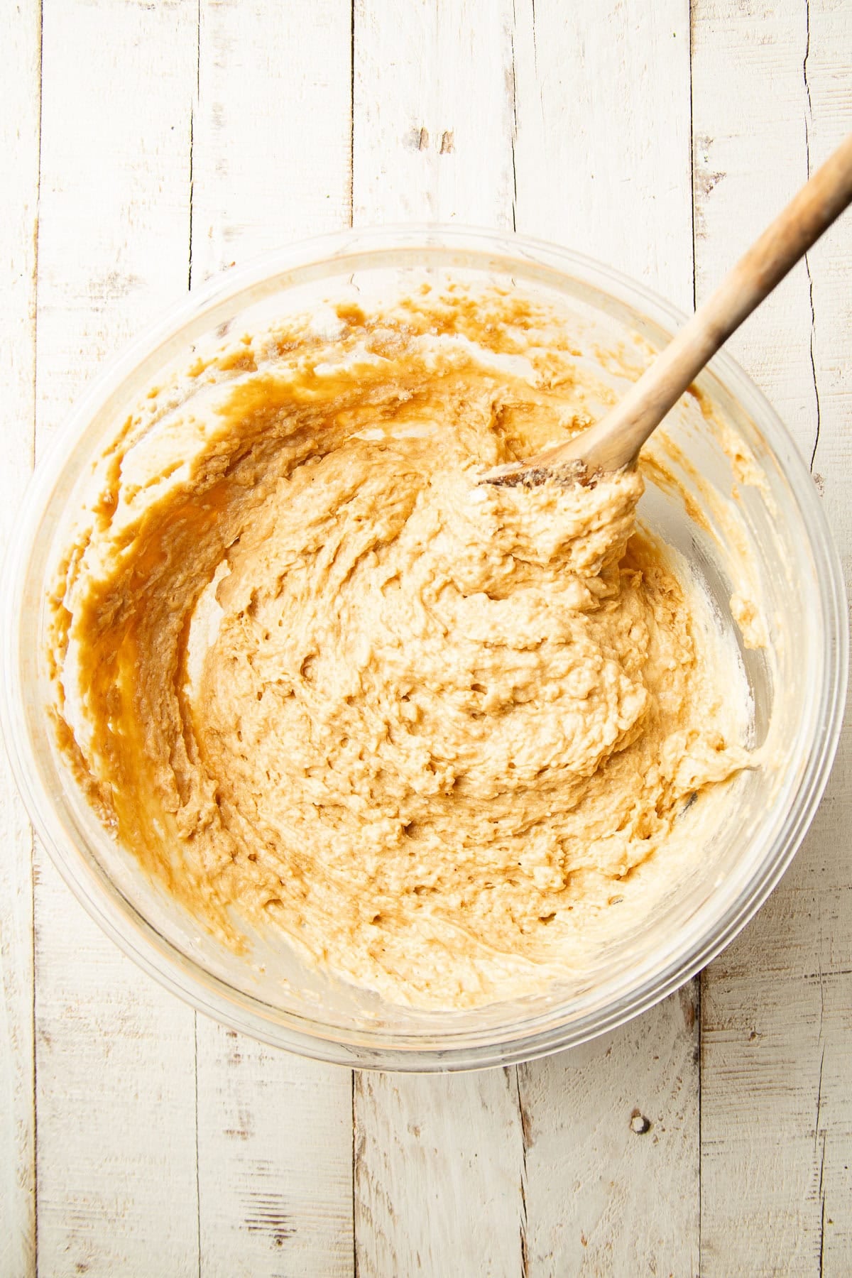 Peanut Butter Bread batter in a mixing bowl with wooden spoon.