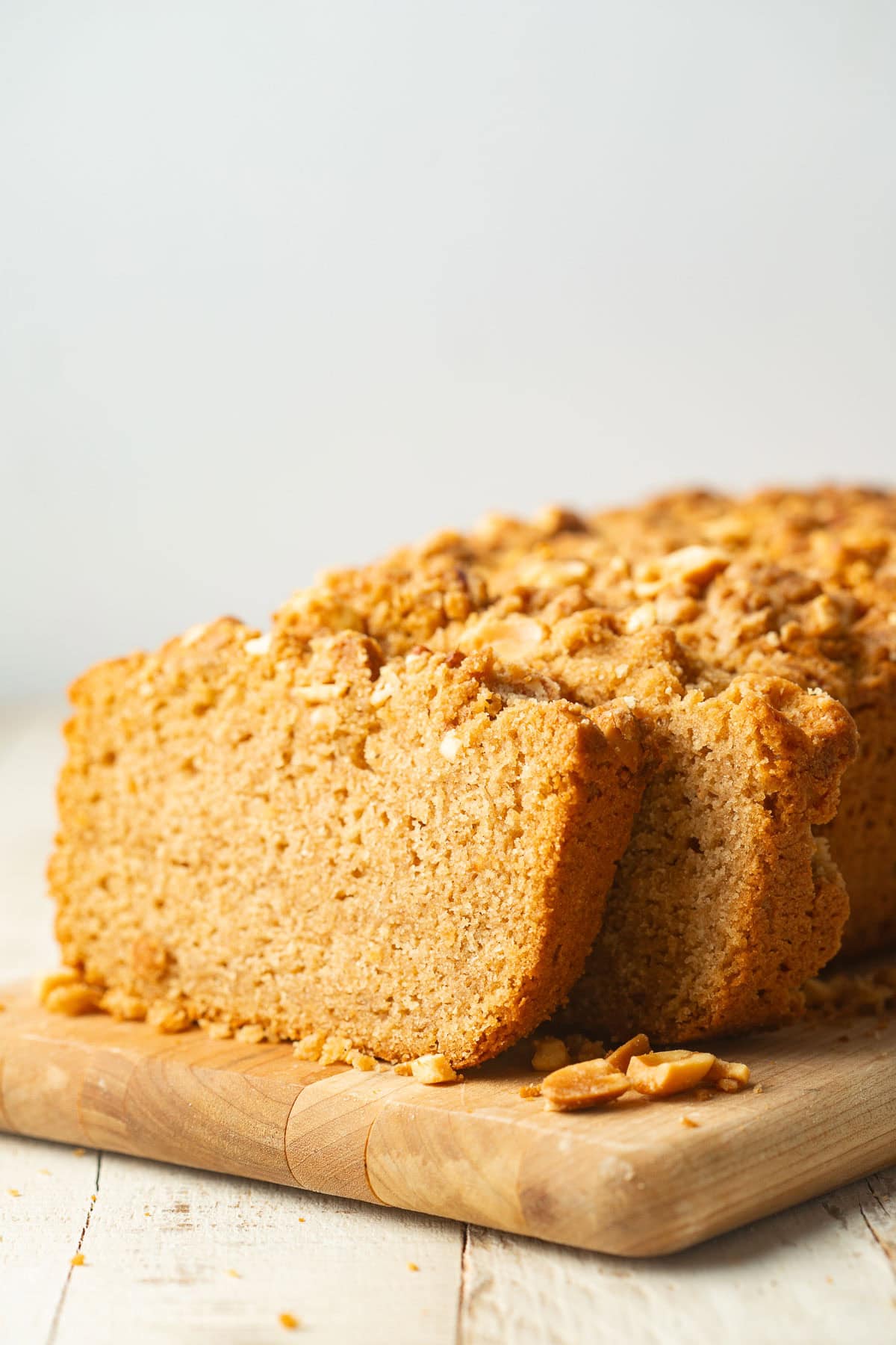 Partially sliced loaf of Peanut Butter Bread on a wooden board.
