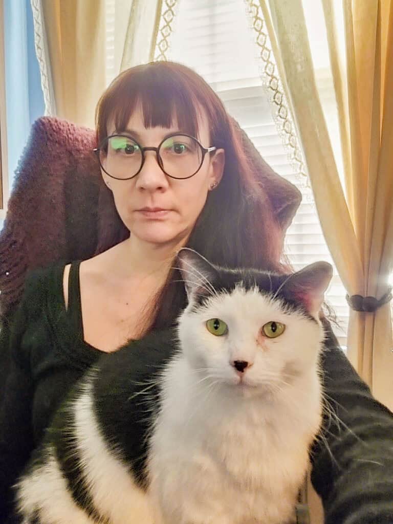 Woman sitting with a cat on her lap.