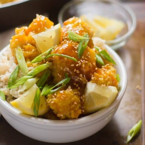 Bowl of Sticky Lemon Cauliflower with rice and lemon slices.