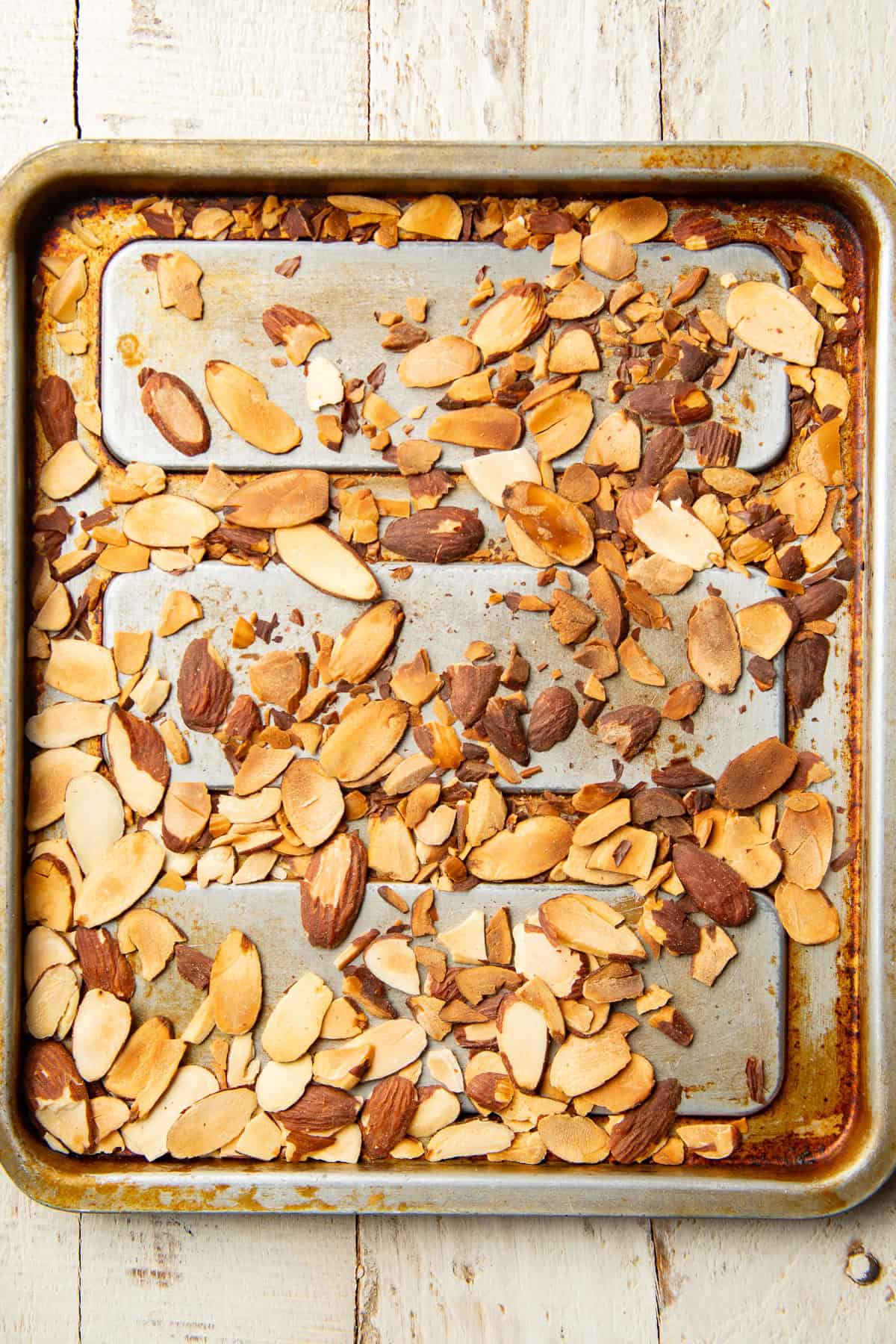 Toasted slivered almonds on a baking sheet.