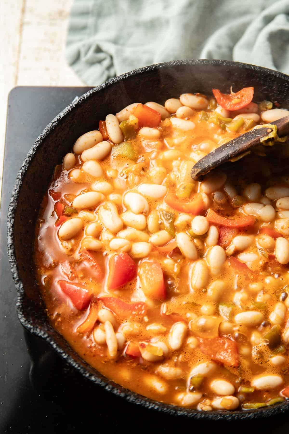 White beans simmering in a skillet.