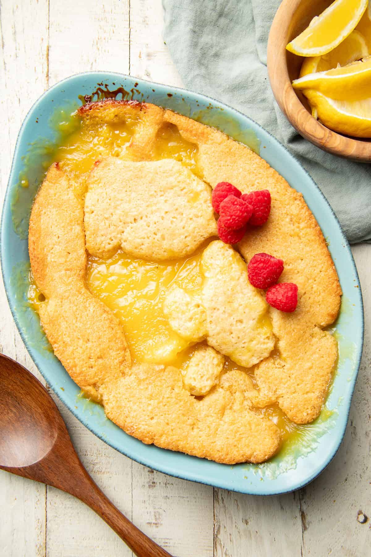 Lemon Cobbler in a baking dish with raspberries on top/