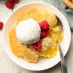 Bowl of Lemon Cobbler with vegan vanilla ice cream and raspberries.